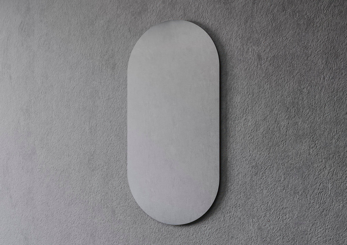 Espejo ALICE LUZ en forma de cápsula, sin marco, apagado sobre una pared gris