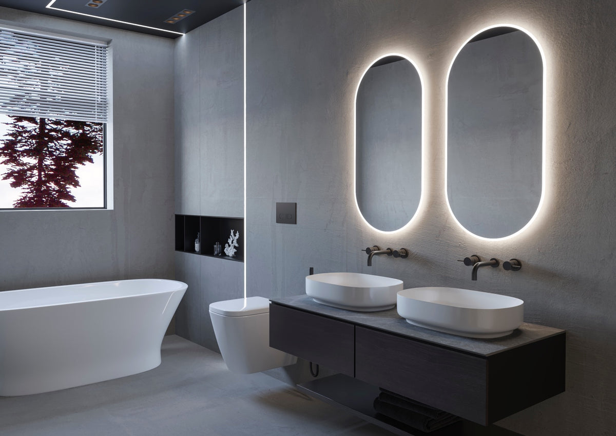 Dos espejos Denor ovalados retroiluminados en un baño con bañera