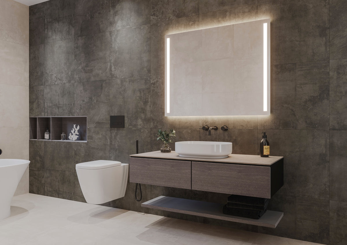 Espejo de baño rectangular HERA encendido, con luz frontal en dos franjas laterales y luz ambiental arriba y abajo, sobre un mueble de madera